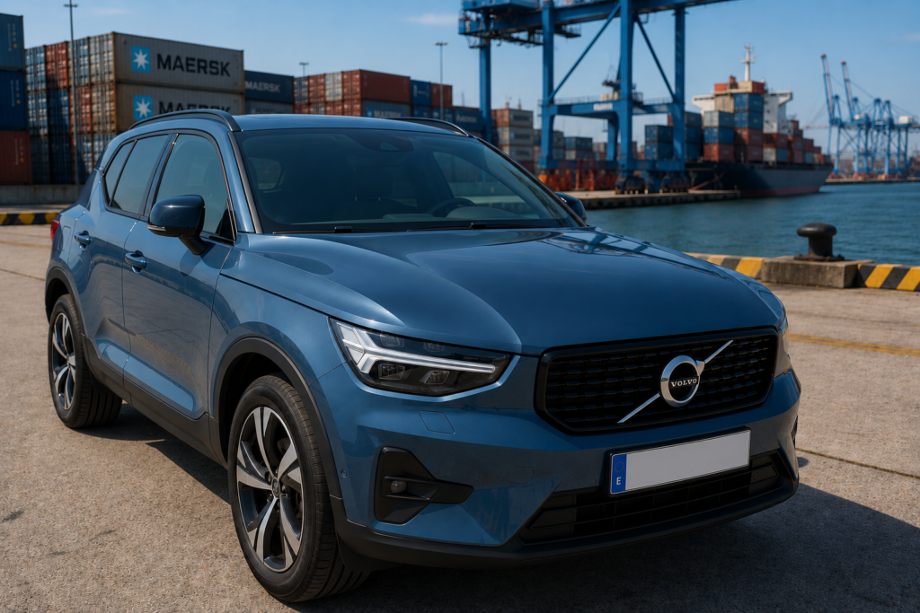 Volvo XC40 azul denim de 2023 estacionado en una terminal portuaria junto a documentos administrativos, ilustrando las dificultades para exportar un coche con cargas.
